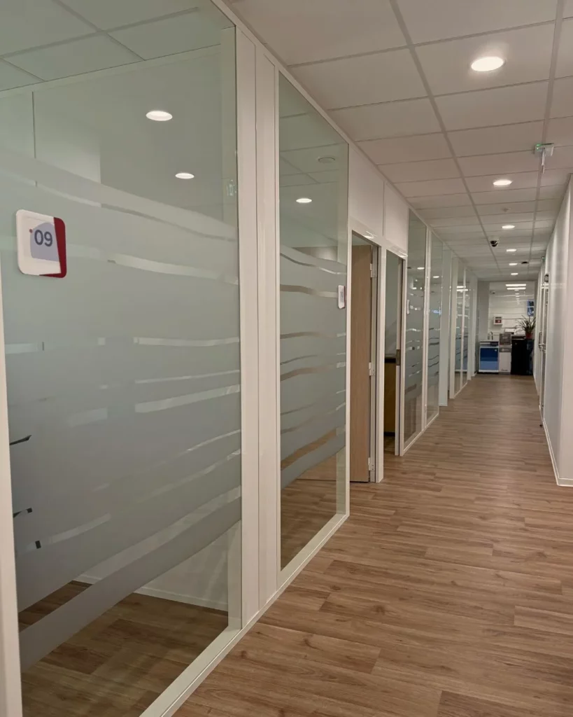 couloir d'une entreprise avec cloisons amovibles vitrées pour séparer espaces